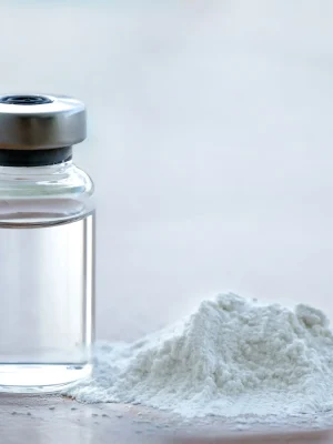 Fine white ketamine powder displayed alongside a pharmaceutical bottle containing liquid ketamine, a premium product by Psychedelic Deals