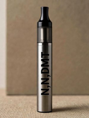 A sleek gray N,N,DMT Vape Pen showing golden-hued oil at the top, standing upright against a soft blurred background with the text N,N,DMT Vape Pens printed in black.